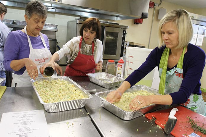 Lisa Nunez, center, pours some broth over the cornbread dressing prepared by Sue Brassard, left, and Julie Barkley, right. For Nunez and Brassard, it was their third year of assisting with the annual Denney Tower Thanksgiving dinner. It was the second year for Barkley, but in 2014 she worked with the serving team. Photo By Michael Alexander