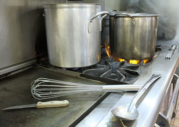 Gravy cooks on the stove in the pot on the left and potatoes cook in the two pots on the right in the University of Georgia Catholic Center kitchen. Mashed potatoes were one of the items on the Thanksgiving dinner menu at the Jesse B. Denney Tower in Athens. Photo By Michael Alexander