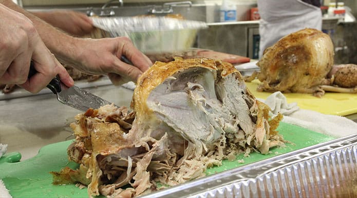 Mike Deom slices up one of the six turkeys cooked for the 20th annual Denney Tower Thanksgiving dinner. Photo By Michael Alexander