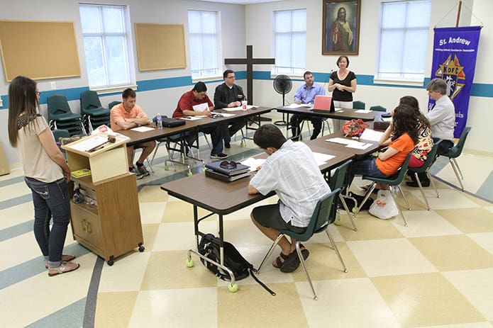 Kelly Akin, standing left, acting âtoastmaster of the dayâ for the May 22 meeting, yields the floor to Meghan Riley, standing right, as she explains the rules for timing before the speeches start for the evening. Photo By Michael Alexander