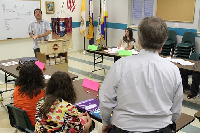 YAM Toastmasters Club member William Brust, standing at the podium, evaluates the speech given by John Baker, standing foreground. Brust is a member of St. Peter Chanel Church, Roswell and Baker is a member of St. Brigid Church, Johns Creek. Photo By Michael Alexander