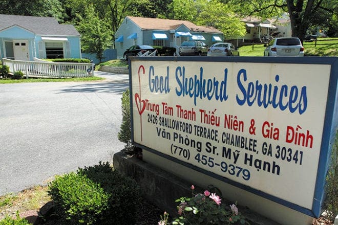Photo: Under “Good Shepherd Services” on the sign, the words in Vietnamese translate to Youth and Family Services. The two blue houses in the background are two of the fours buildings on the property used for various classes, events and programs.