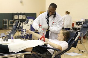 After donating a pint of blood Blessed Trinity High School junior Savannah Grace is assisted by American Red Cross blood collection tech Lorenzo Holmes during the school's Jan. 25 blood drive. Grace was a first-time donor. (Photos By Michael Alexander) 