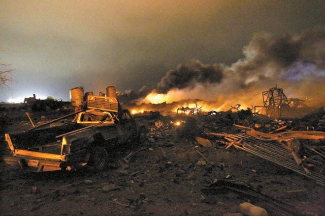 A vehicle is seen near the burning remains of a fertilizer plant in West, Texas, April 18, after an explosion there the previous day. Rescue workers searched rubble for survivors of the plant explosion in a small town near Waco that killed 14 people and injured more than 160 others.