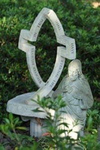 In the Nelson garden sunlight shines on the face of the Sacred Heart of Jesus statue as the verse from John 3:15 appears in the background. (Photo By Michael Alexander)