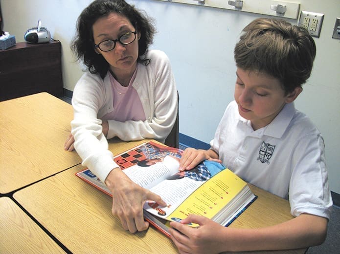 Felice Atkinson helps a student with his reading. For her work with special education students, Atkinson was honored as an outstanding teacher.