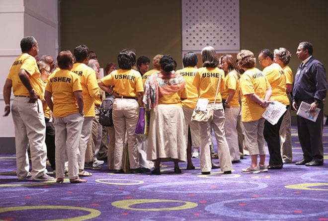 Volunteer ushers gather for a meeting before the 5 p.m. vigil Mass for Corpus Christi, the closing event of the 2014 Eucharistic Congress. The annual congress depends on the generosity of many people who give of their time to serve in various capacities. Photo By Michael Alexander