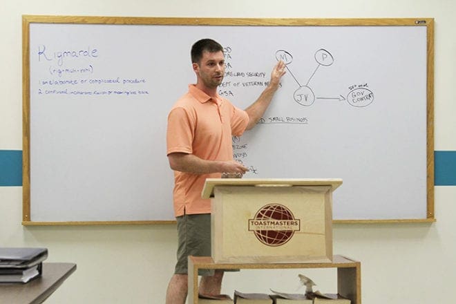 Wes Cross of Dunwoody uses the board as he gives a speech on government contracts for small businesses. Cross, who works for his father’s general contracting business in Cumming, has been a member of the YAM Toastmasters Club for a year. Photo By Michael Alexander