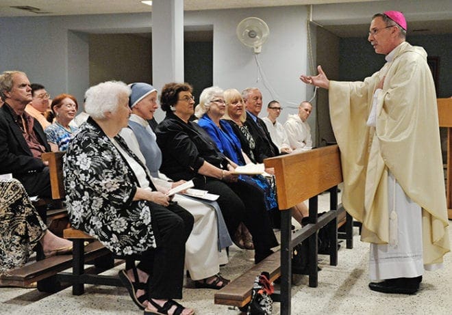 Bishop Luis R. Zarama speaks informally with Sister Mary Beatrice Raphael before she professes her vows as a consecrated woman to live the eremitic life. Sister Beatrice is flanked by Immaculate Heart of Mary Sister Margaret McAnoy on the left and her family on the right. Sister Margaret, vicar for religious, assisted Sister Beatrice as she prepared for consecrated life. Photo By Lee Depkin