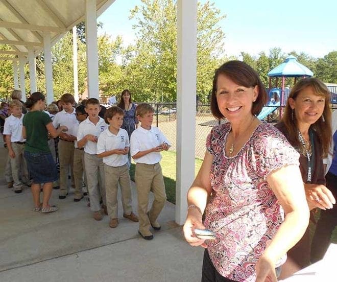 Anne Hamilton, Pinecrest Academy’s development coordinator, and Lucy Daniels, receptionist, hand out cookies to Lower School students Sept. 30 after the school community learned Pinecrest was chosen a National Blue Ribbon School of Excellence. Photo By Vivian Heard