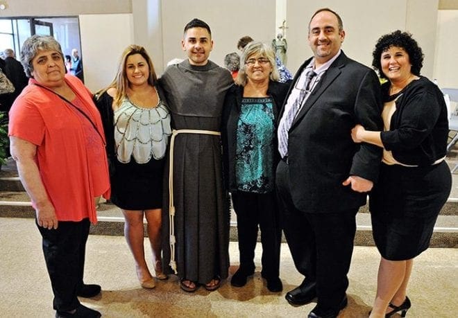 During the reception in the parish hall Father Gabriel Scasino poses with family members who attended his ordination. From left are Nancy Demaio, his aunt; Arianna Scasino, his niece; Father Gabriel; Mary Ann Scasino, his mother; Anthony Scasino, his brother and Alberta Scasino, his sister-in-law. Photo By Lee Depkin