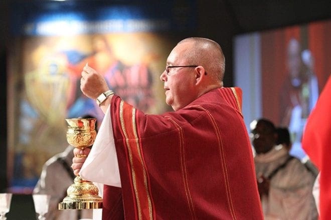 Serving as the main celebrant and homilist for the June 5 opening Mass of the Eucharistic Congress, Bishop David P. Talley holds the body and blood of Christ before the congregation during the Lamb of God prayer.