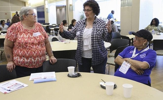 Sally Peters, left, and Mary Q. Rice, seated, of St. Matthew Church, Tyrone, and Lynda Mesko of St. James the Apostle Church, McDonough, discuss the challenges of trying to address the needs of impoverished people in suburban areas. All three women work with the St. Vincent de Paul councils at their respective churches. Photo By Michael Alexander