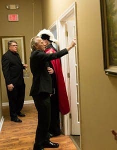 Father Neil Herlihy, pastor of St. Brigid Church, Johns Creek, blesses the newly opened Pregnancy Aid Clinic in Roswell Oct. 1 with the assistance of Deacon Dennis Dorner, left, chancellor of the archdiocese.