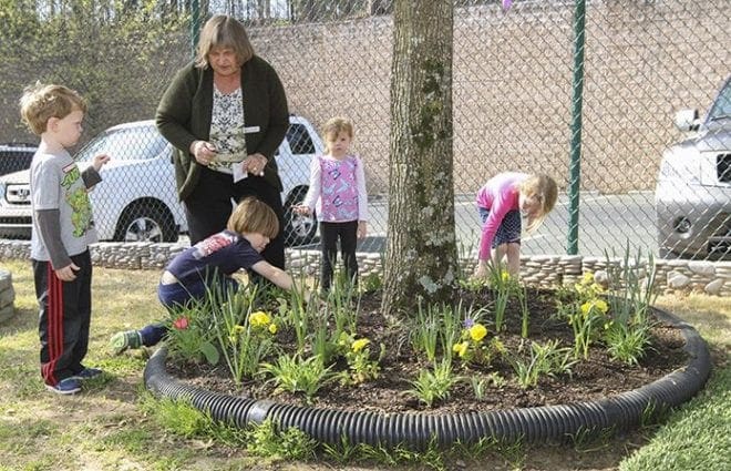 Our Lady of the Assumption preschool teacher Jaroslava "Jerry" Patak distributes zinnia seeds to (l-r) Matthew Morrison, Brando Tabor, Ellis Anne Brady and Sammie Barton as they do some planting in the preschool garden March 23. Photo By Michael Alexander