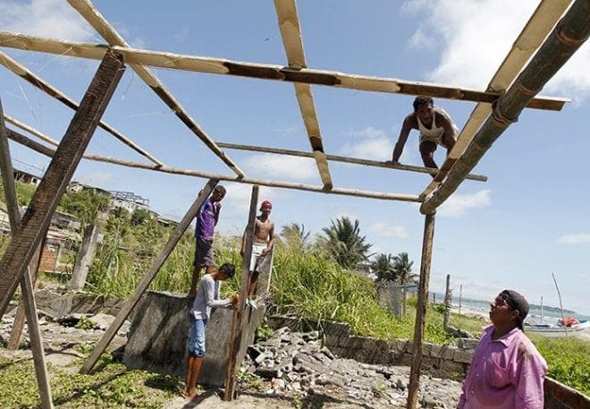 A man works on the roof as he rebuilds his house April 25 in Pedernales, Ecuador. CNS Photo/Guillermo Granja, Reuters