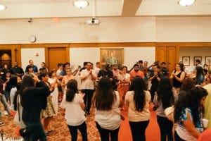 After Mass, clergy, pilgrims and family members gather for food, song and dance in the Cathedral of Christ the King's Kenny Hall. Photo By Bau Nguyen