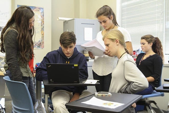 (L-r) Marist School junior student leader Claire Boerner observes sophomores Liam Dunn, Olivia Shutley, Lauren Jennings and Madelyn Jardina work on editing their public service announcement video on the issue of human trafficking. It was one aspect of the school’s Oct. 13 Informed Discourse Day, a day for dialogue, discussion and debate exploring human trafficking. Photo By Michael Alexander 