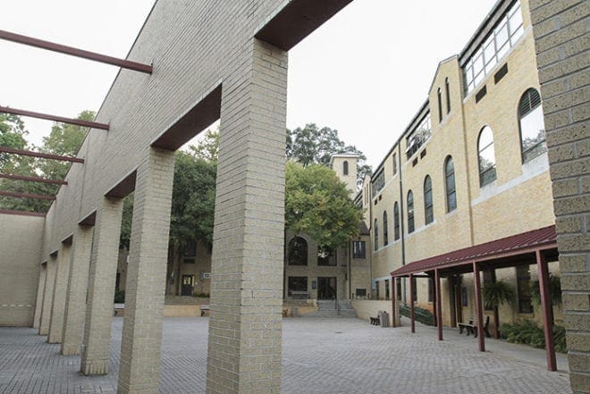 Peering through the columns of Mulhern Hall provides a view of the school building, right, and the church, background. Mulhern Hall, the parish activity center, was dedicated in 1994 in honor of its beloved pastor Father Patrick Mulhern. Father Mulhern, who died nearly a decade ago, was the pastor from 1987-1999. Photo By Michael Alexander